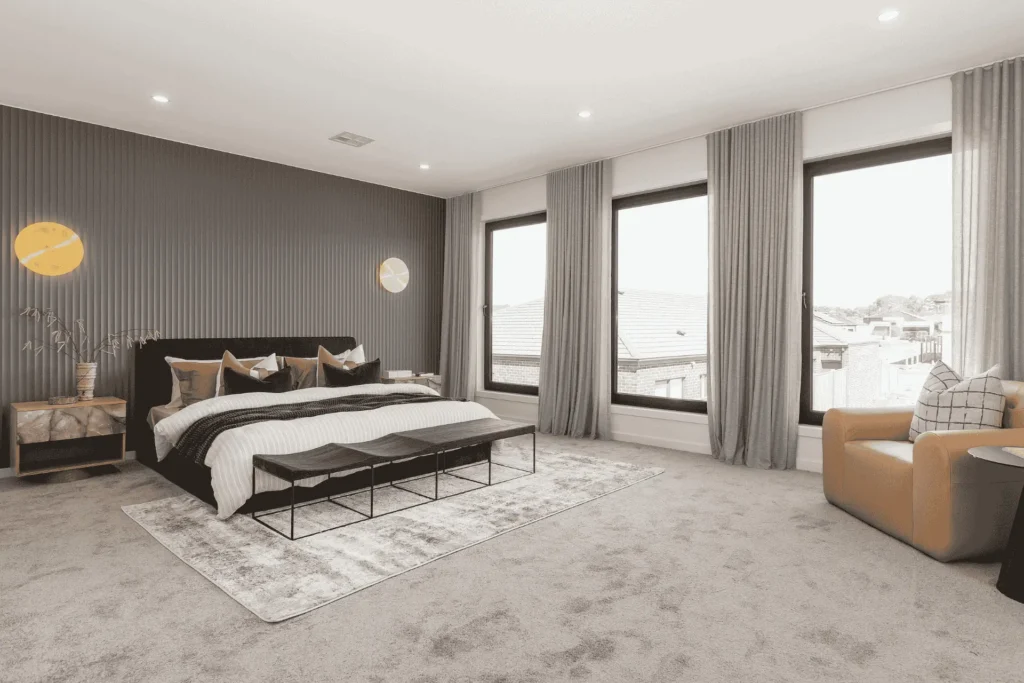 Spacious bedroom with three large windows letting in natural light